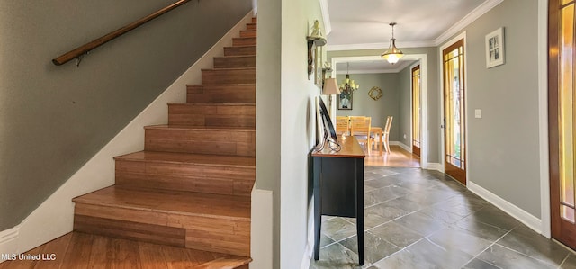 staircase featuring crown molding and a chandelier