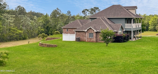 exterior space featuring a lawn, a balcony, and cooling unit