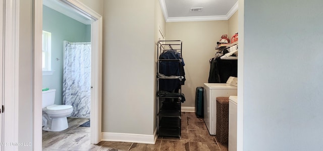 laundry area featuring crown molding and washing machine and clothes dryer