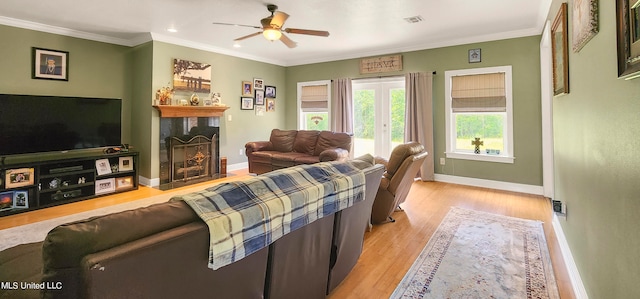 living room with crown molding, light hardwood / wood-style flooring, and ceiling fan