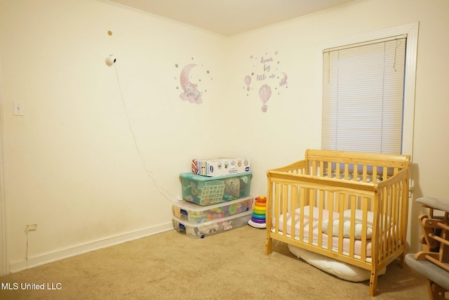 carpeted bedroom featuring ornamental molding and a crib