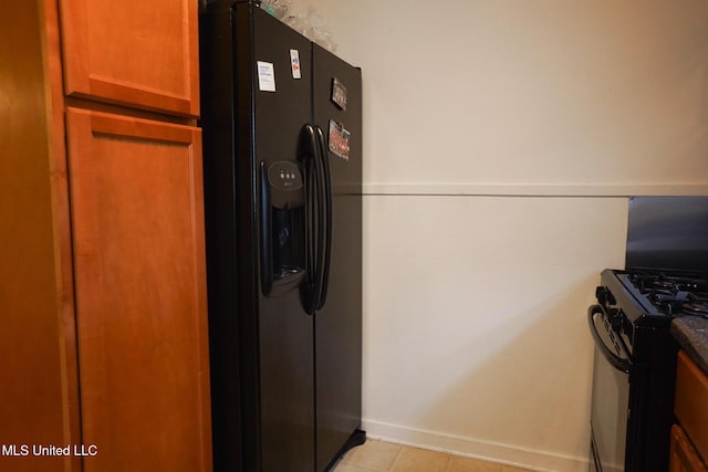 kitchen featuring tile walls, light tile patterned floors, and black appliances