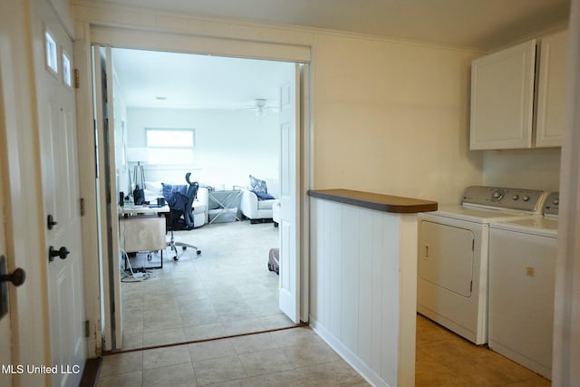 washroom with cabinets, ceiling fan, crown molding, and washer and clothes dryer