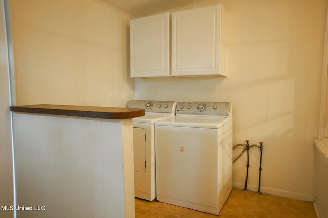 laundry area with washer and dryer, light tile patterned floors, and cabinets