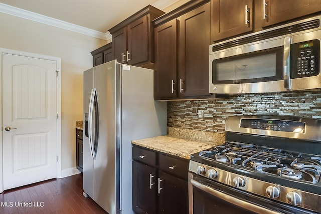 kitchen with dark wood-type flooring, stainless steel appliances, backsplash, ornamental molding, and dark brown cabinetry