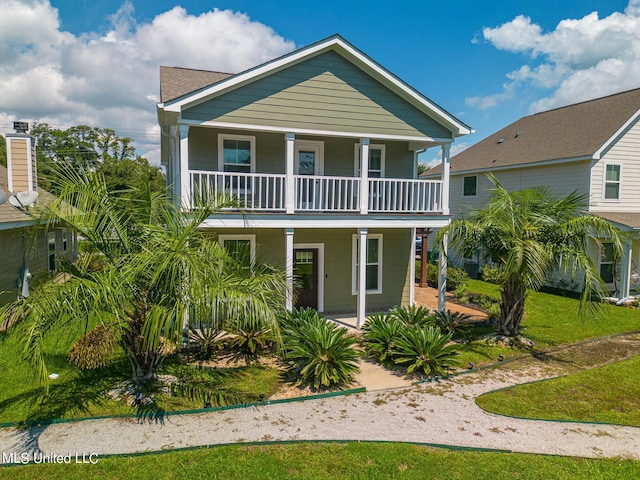 coastal home with a porch and a front yard