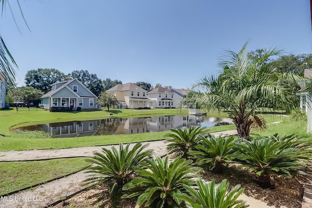 view of community with a water view and a lawn