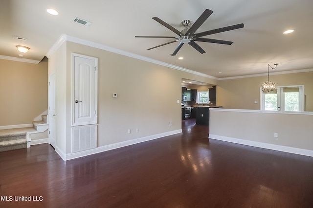 spare room with ceiling fan with notable chandelier, ornamental molding, and dark hardwood / wood-style floors