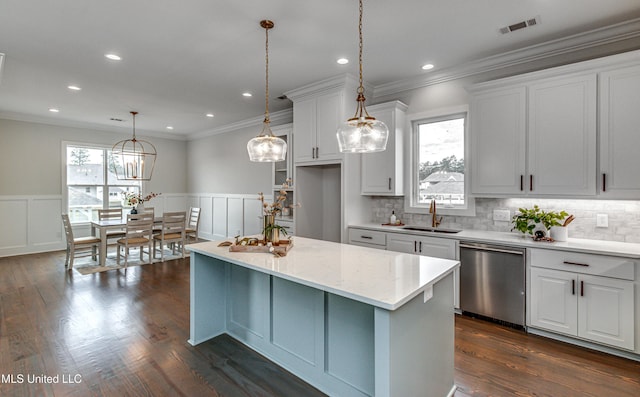 kitchen with stainless steel dishwasher, dark wood-type flooring, sink, pendant lighting, and white cabinetry