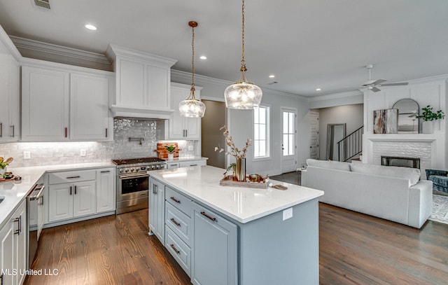 kitchen featuring appliances with stainless steel finishes, white cabinetry, a kitchen island, and dark wood-type flooring