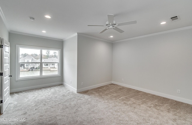 spare room featuring ceiling fan, ornamental molding, and light carpet