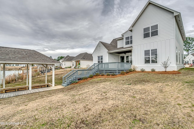 rear view of house featuring a yard and a deck