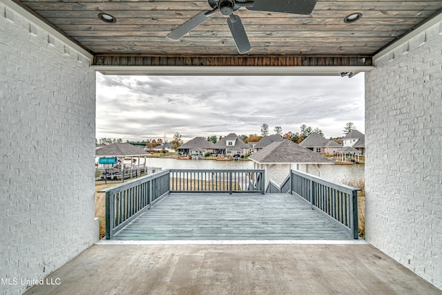 wooden deck with ceiling fan and a water view