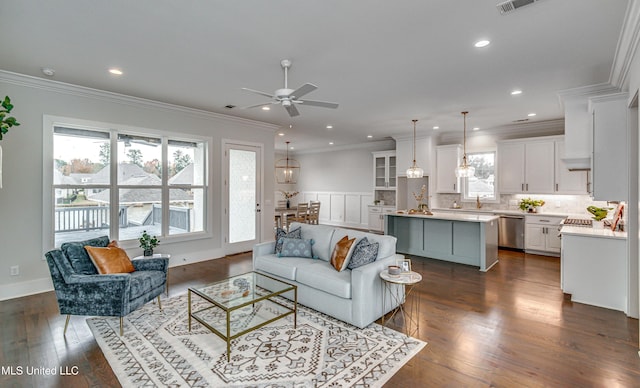 living room featuring ceiling fan, ornamental molding, and dark wood-type flooring