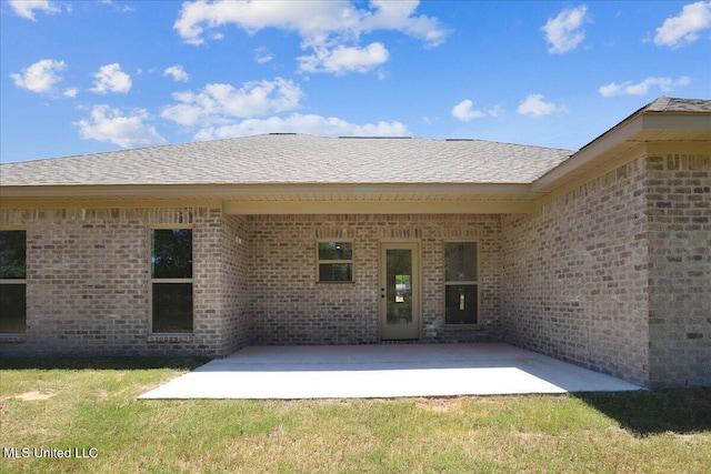 107 NE Adams Ave, Magee, MS 39111 - back of property with a patio, brick siding, a yard, and roof with shingles