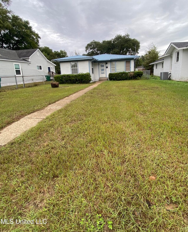 view of front facade with a front yard and cooling unit