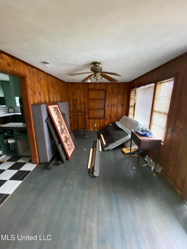 misc room featuring dark wood-type flooring, wooden walls, and ceiling fan