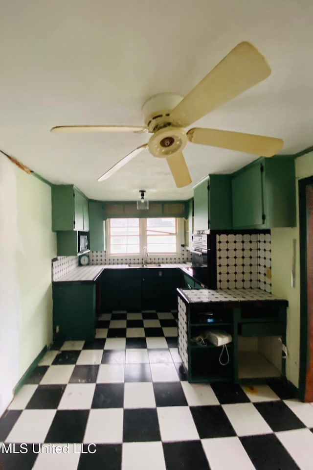 kitchen featuring tile counters, ceiling fan, sink, and green cabinetry