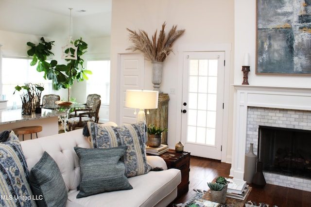 living area with a wealth of natural light, a fireplace, and wood finished floors