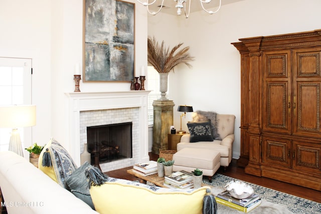 living room featuring a notable chandelier, a fireplace, and wood finished floors