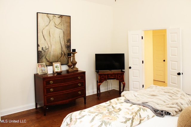 bedroom with dark wood-type flooring and baseboards