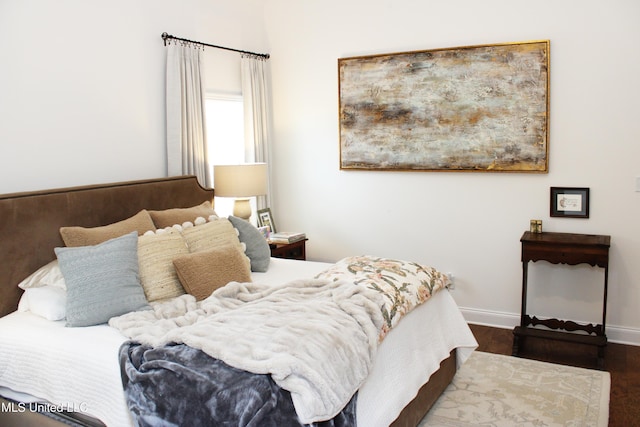 bedroom featuring baseboards and wood finished floors