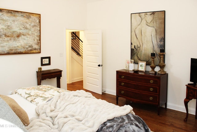 bedroom with baseboards and dark wood finished floors