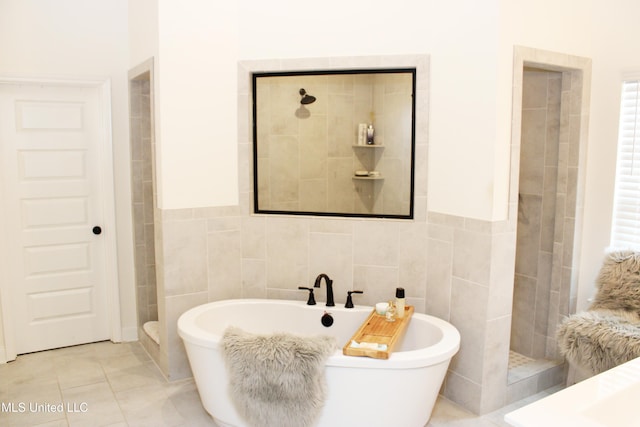 bathroom featuring a freestanding bath, walk in shower, tile walls, and tile patterned floors