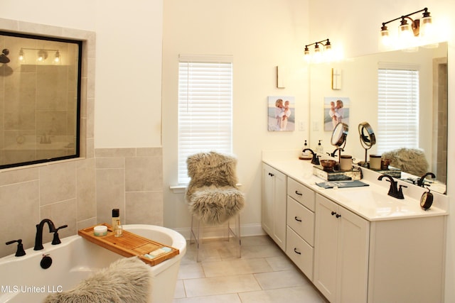 bathroom featuring double vanity, tile patterned floors, a tile shower, a freestanding bath, and a sink