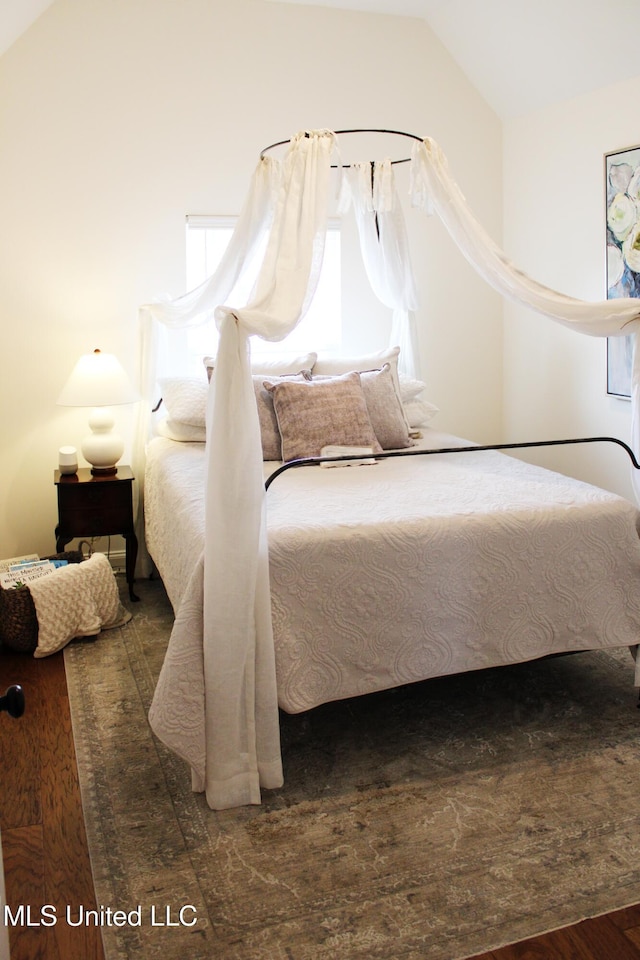 bedroom featuring lofted ceiling and wood finished floors