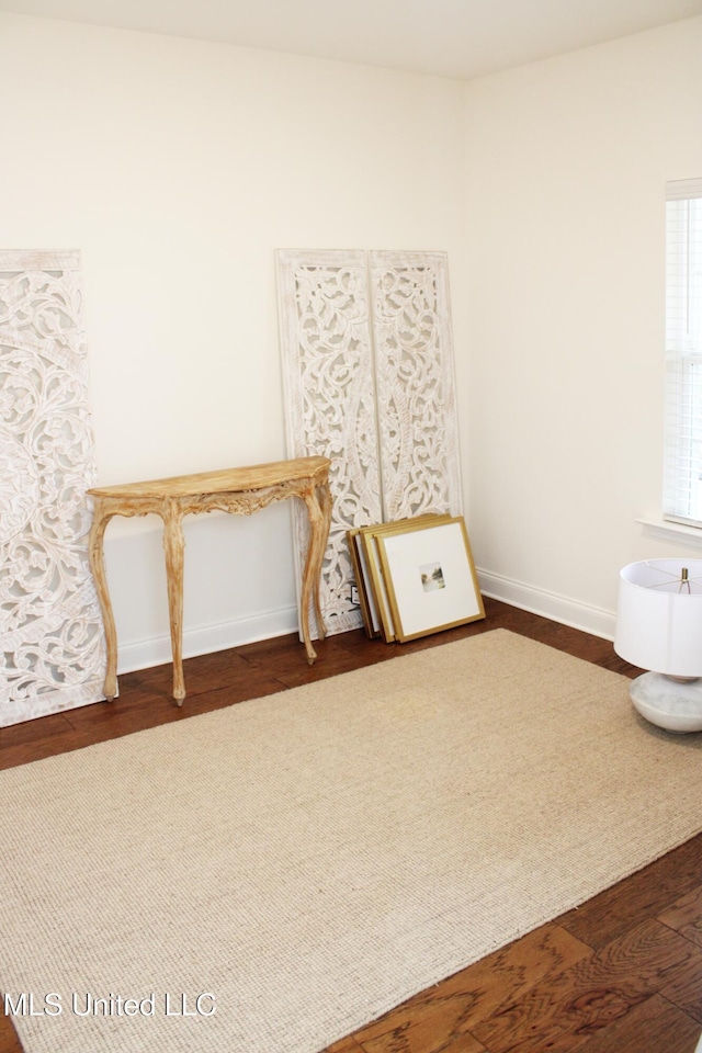 interior space featuring dark wood-type flooring and baseboards