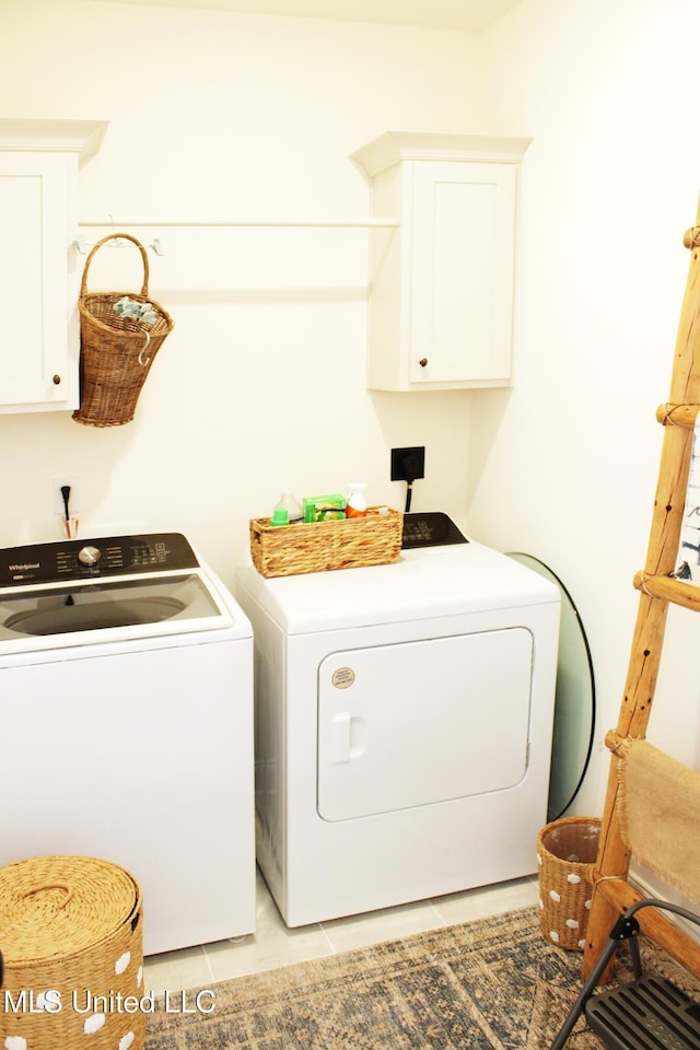 laundry room featuring cabinet space, washer and clothes dryer, and light tile patterned flooring