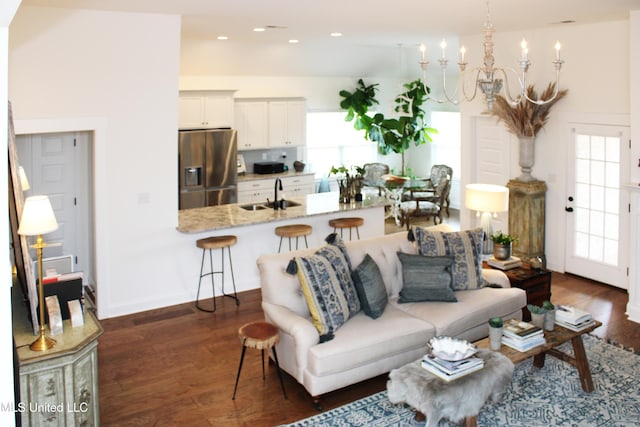 living area featuring dark wood-type flooring, recessed lighting, baseboards, and an inviting chandelier