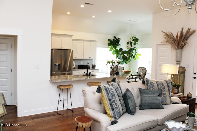 living area featuring baseboards, visible vents, dark wood-type flooring, and recessed lighting