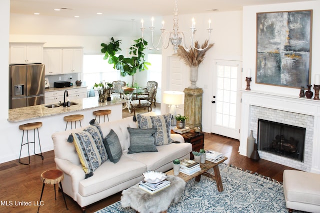 living room featuring dark wood-type flooring, a wealth of natural light, and a notable chandelier