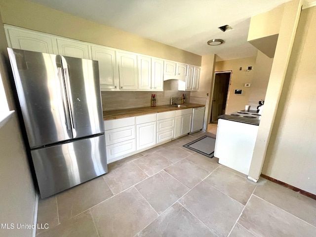 kitchen with backsplash, freestanding refrigerator, white cabinetry, white dishwasher, and a sink