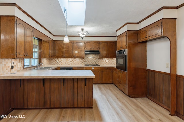 504 Hampton St, Clinton, MS 39056 - kitchen featuring black oven, a sink, a peninsula, light wood finished floors, and a wainscoted wall