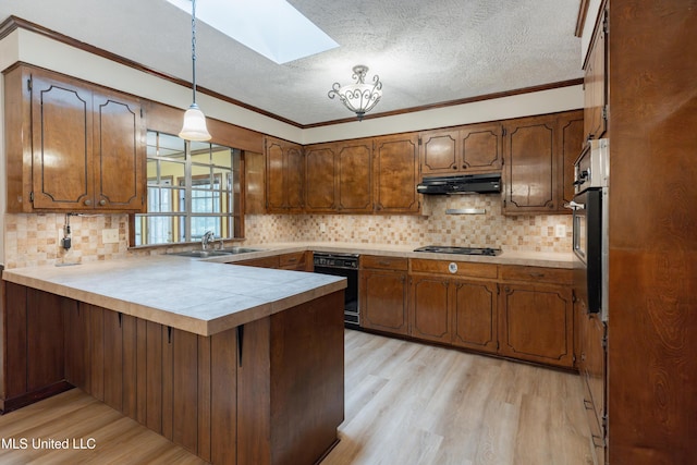 504 Hampton St, Clinton, MS 39056 - kitchen featuring a peninsula, a skylight, light wood-style flooring, under cabinet range hood, and a textured ceiling