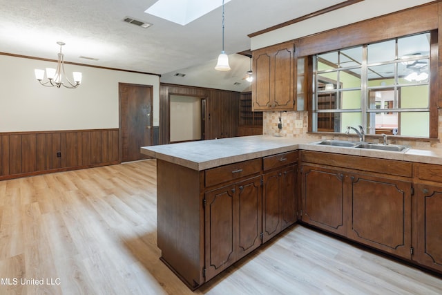 504 Hampton St, Clinton, MS 39056 - kitchen featuring a sink, a skylight, light wood-style flooring, a peninsula, and light countertops