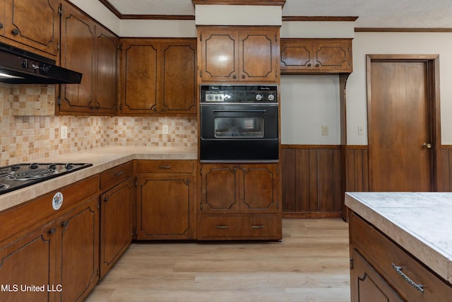 504 Hampton St, Clinton, MS 39056 - kitchen with black appliances, under cabinet range hood, light wood finished floors, light countertops, and ornamental molding