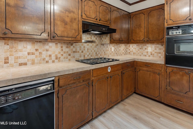 504 Hampton St, Clinton, MS 39056 - kitchen with black appliances, under cabinet range hood, light countertops, light wood finished floors, and crown molding