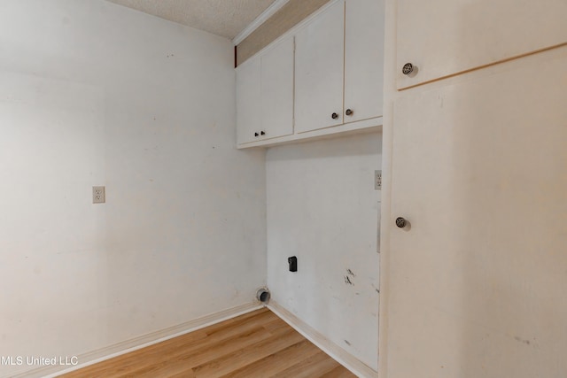 504 Hampton St, Clinton, MS 39056 - washroom featuring cabinet space, light wood finished floors, a textured ceiling, and baseboards
