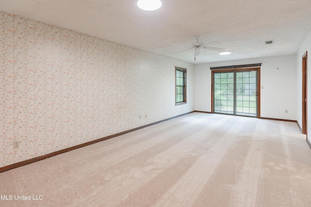 504 Hampton St, Clinton, MS 39056 - empty room with wallpapered walls, ceiling fan, light colored carpet, and baseboards