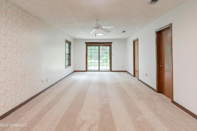 504 Hampton St, Clinton, MS 39056 - unfurnished room featuring wallpapered walls, ceiling fan, baseboards, a textured ceiling, and light colored carpet