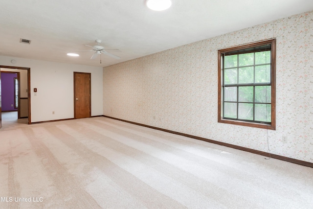 504 Hampton St, Clinton, MS 39056 - empty room featuring light colored carpet, wallpapered walls, a ceiling fan, and baseboards