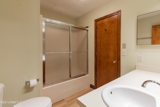504 Hampton St, Clinton, MS 39056 - full bath with wood finished floors, toilet, bath / shower combo with glass door, and vanity