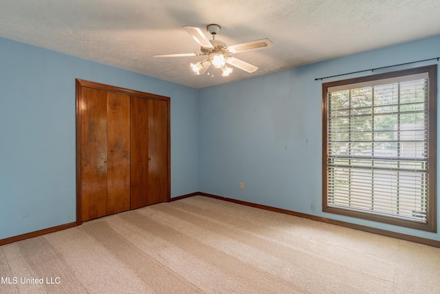 504 Hampton St, Clinton, MS 39056 - unfurnished bedroom with light colored carpet, baseboards, a closet, a textured ceiling, and ceiling fan