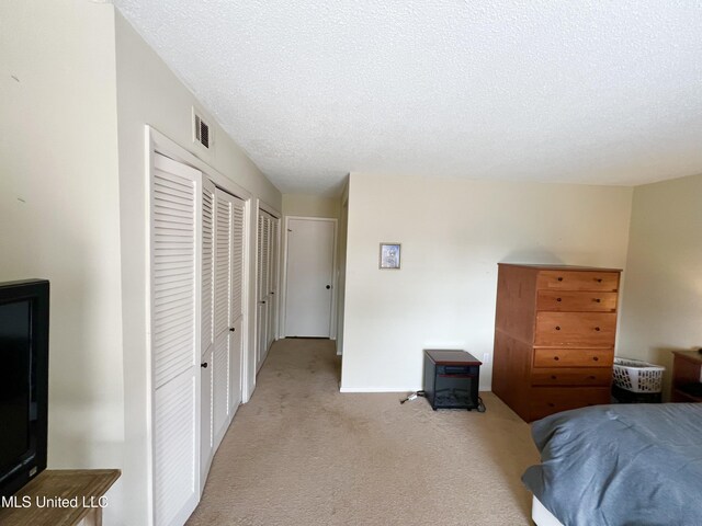 bedroom featuring light carpet and a textured ceiling