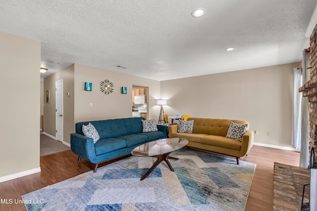 257 Highpoint Dr Unit 257, Diamondhead, MS 39525 - living room with a textured ceiling, a fireplace, wood finished floors, and recessed lighting