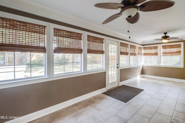 unfurnished sunroom featuring ceiling fan